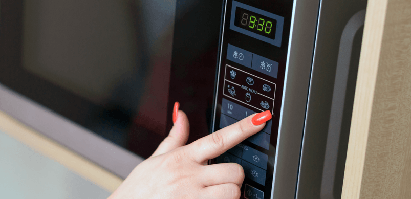 Woman's Hand Pressing Microwave Buttons