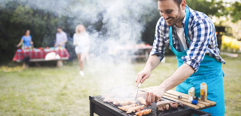 Man Cooking On Barbecue In Garden